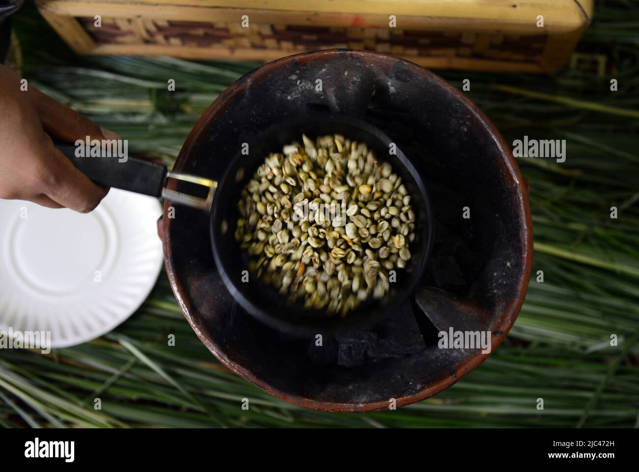 Tostatura dei chicchi di caffè in una tradizionale cerimonia del caffè etiope. Foto Stock