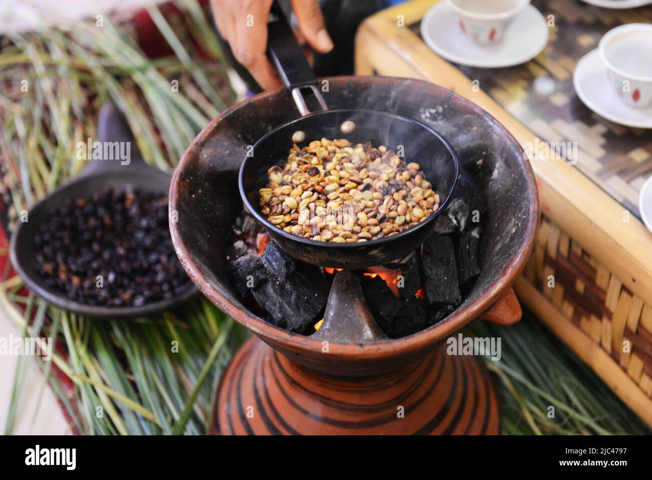 Tostatura dei chicchi di caffè in una tradizionale cerimonia del caffè etiope. Foto Stock