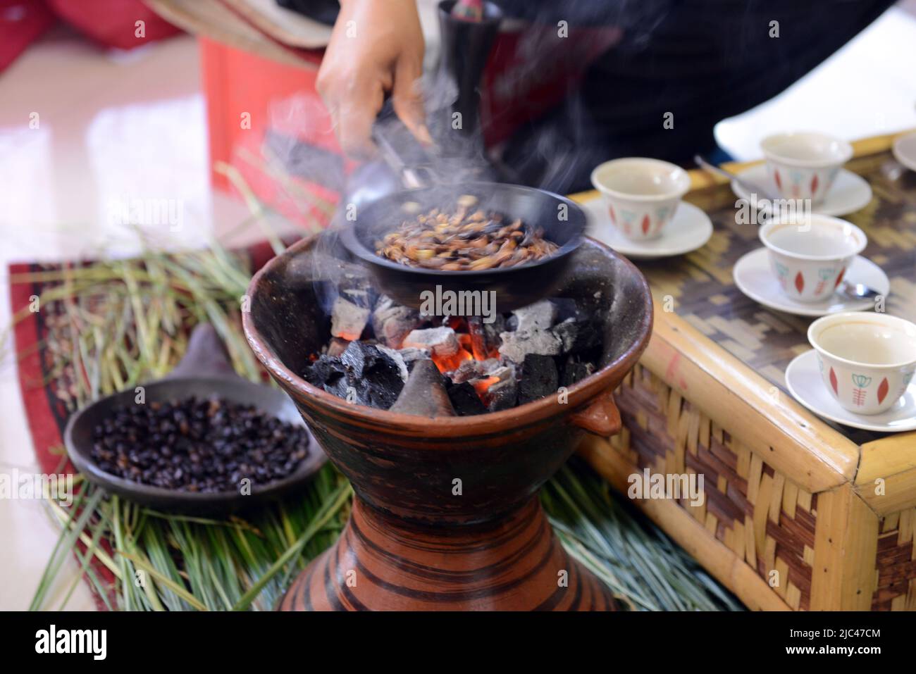 Tostatura dei chicchi di caffè in una tradizionale cerimonia del caffè etiope. Foto Stock