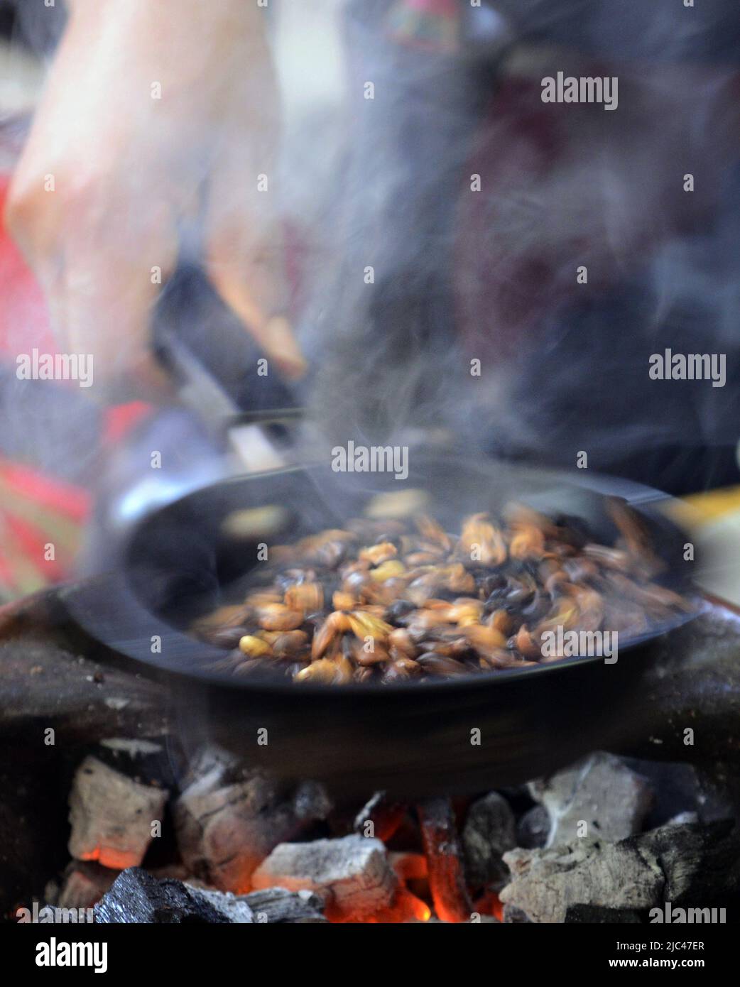 Tostatura dei chicchi di caffè in una tradizionale cerimonia del caffè etiope. Foto Stock