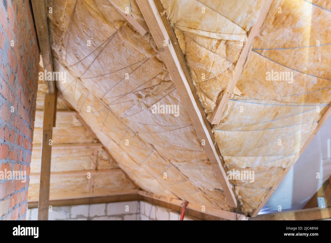 Il tetto è isolato con lana di vetro gialla. Rivestimento isolante con filettatura Foto Stock