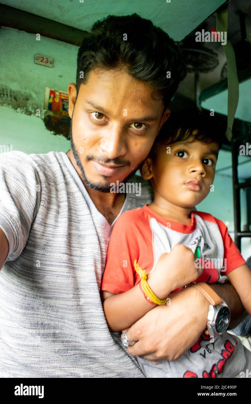 Giovane uomo che tiene un ragazzo indiano e prende un selfi. Foto Stock