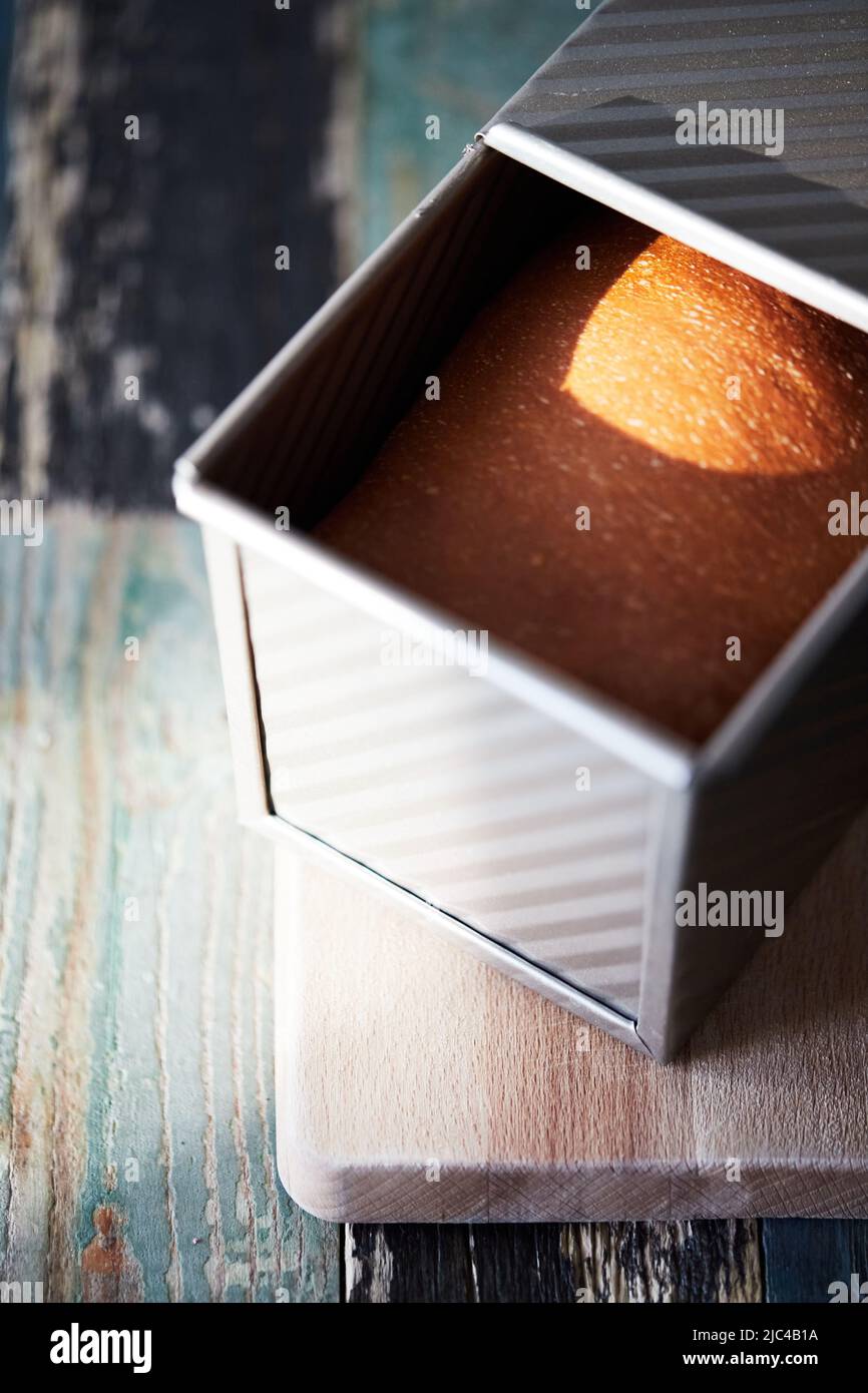 Il processo di preparazione del pane tostato fatto in casa in uno stampo. Il concetto di cibo sano fatto in casa. Foto verticale. Foto Stock