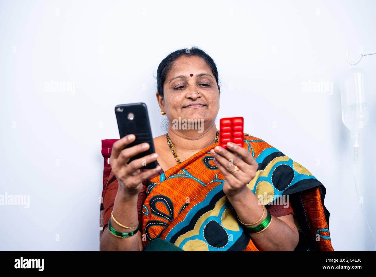Le donne anziane controllano le pillole mentre ordinano le medicine in linea sul telefono mobile nel paese - concetto della farmacia e, della tecnologia e della sanità Foto Stock