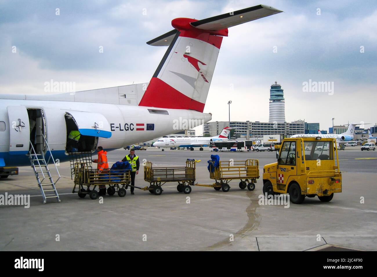 Austrian Arrows Airline scarico bagagli su asfalto, aeroporto internazionale di Vienna, Austria Foto Stock
