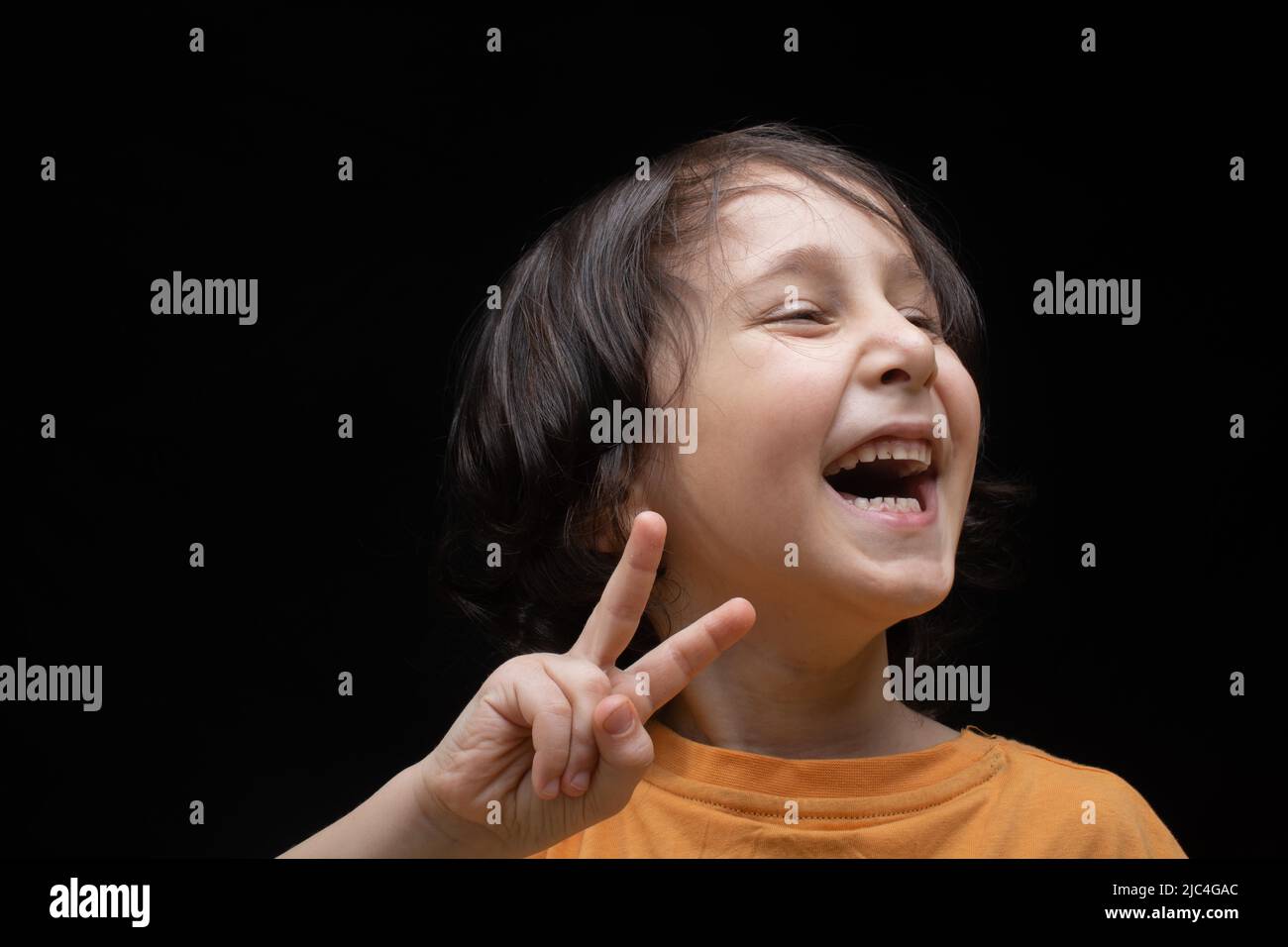 Sorridente ragazzo con faccia felice e vittoria gesto di pace Foto Stock