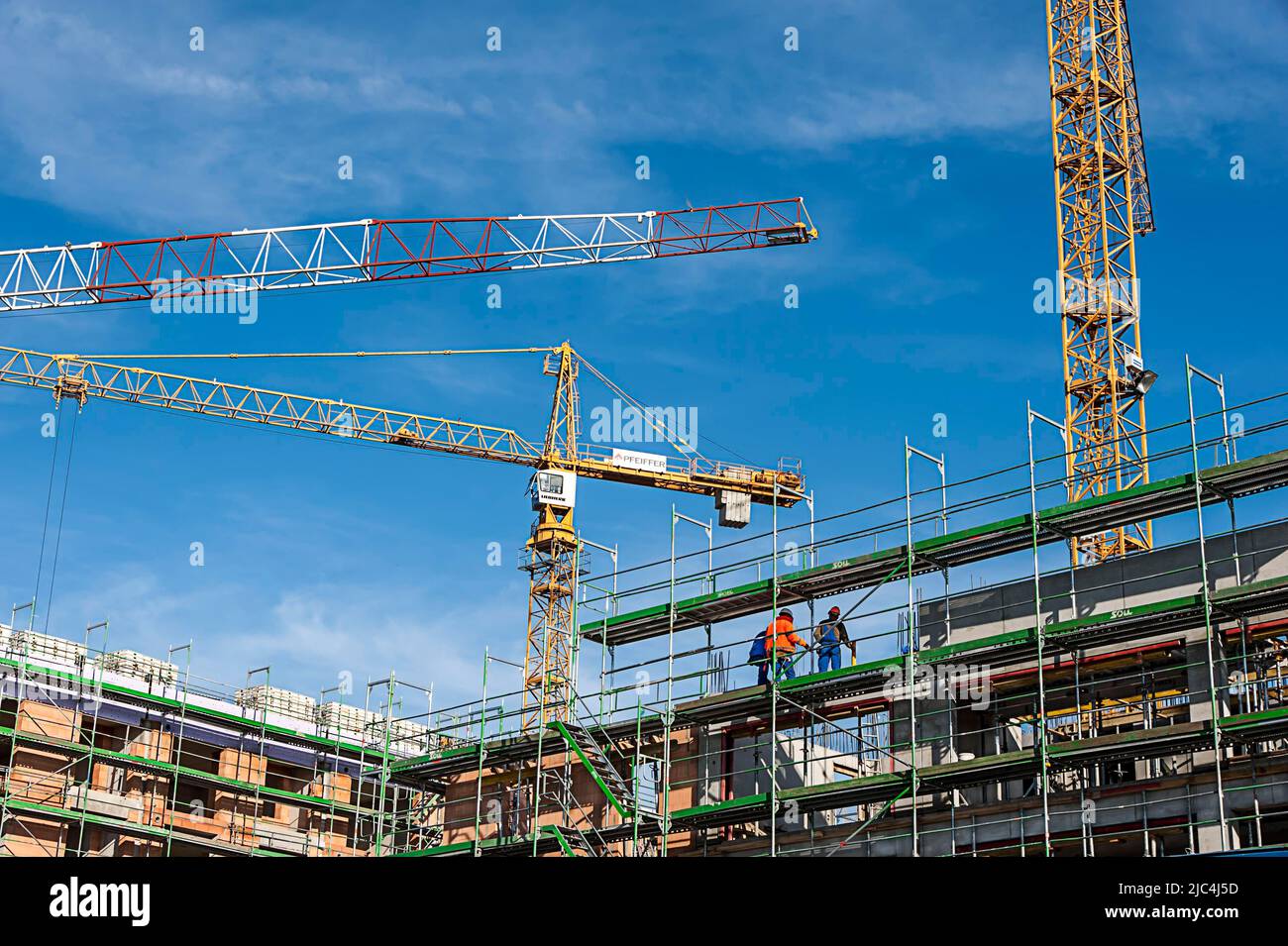Nuova costruzione edilizia residenziale e commerciale, lavoratori edili in cantiere, Monaco, Baviera, Germania Foto Stock