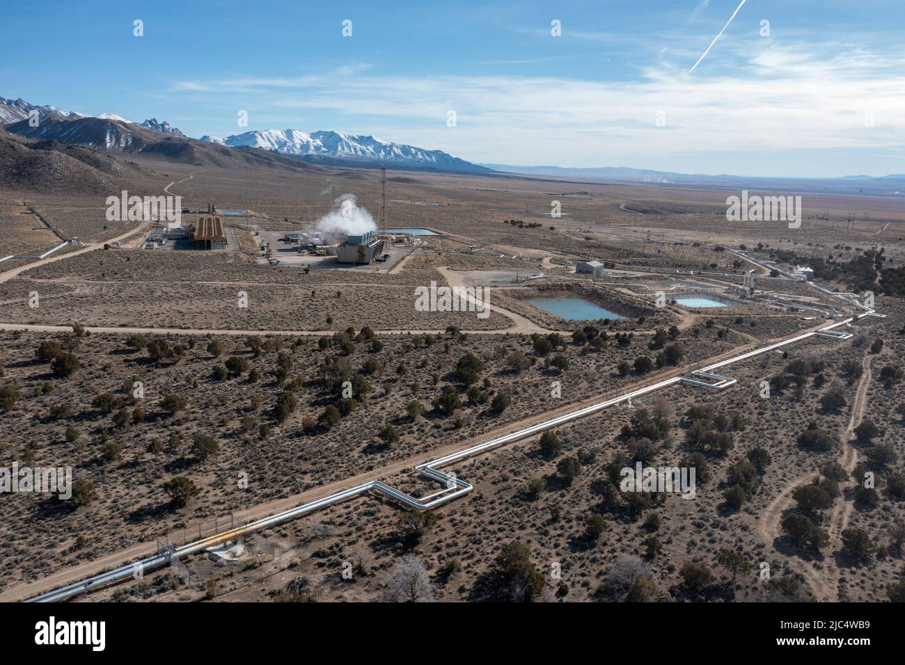 Vapore che sale dalle torri di raffreddamento della centrale geotermica Blundell nello Utah. I tubi del vapore corrono dai pozzi di produzione alla centrale elettrica. Foto Stock