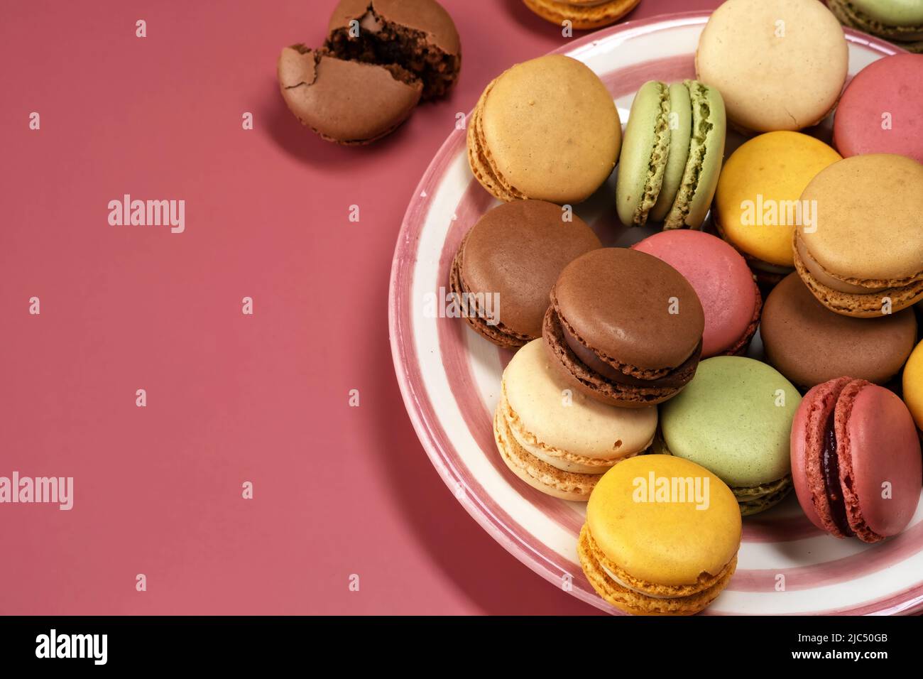 Deliziosi macaroni colorati e dolci su sfondo colorato Foto Stock