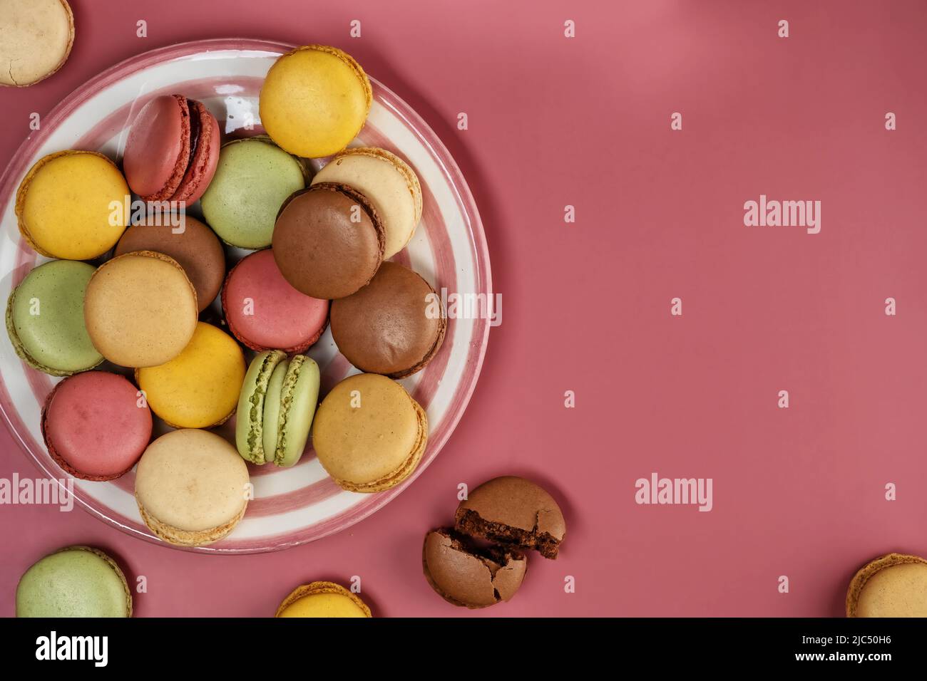 Deliziosi macaroni colorati e dolci su sfondo colorato Foto Stock