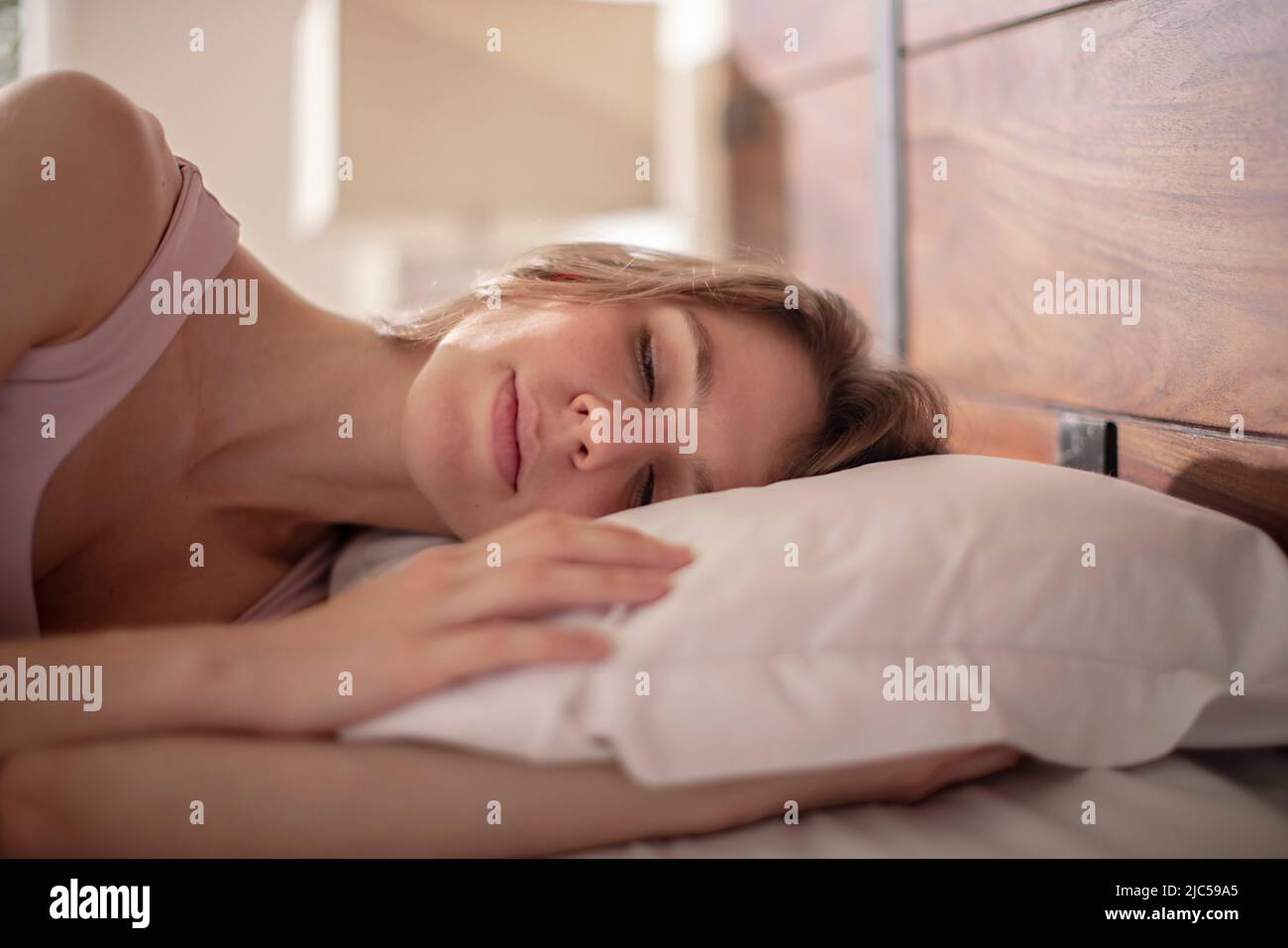 Primo piano di una giovane donna che dorme sul letto Foto Stock
