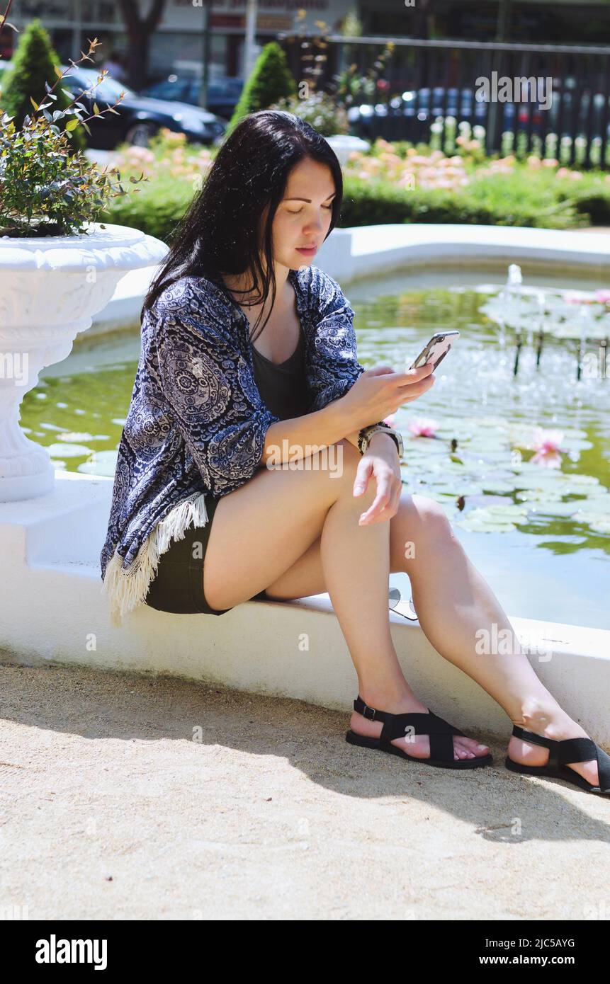 Ritratto di giovane donna felice affari relax in città, parco sul mare Adriatico. Utilizzando il telefono. Selfie. Tecnologia. Social media. Videochiamata. Estate Foto Stock