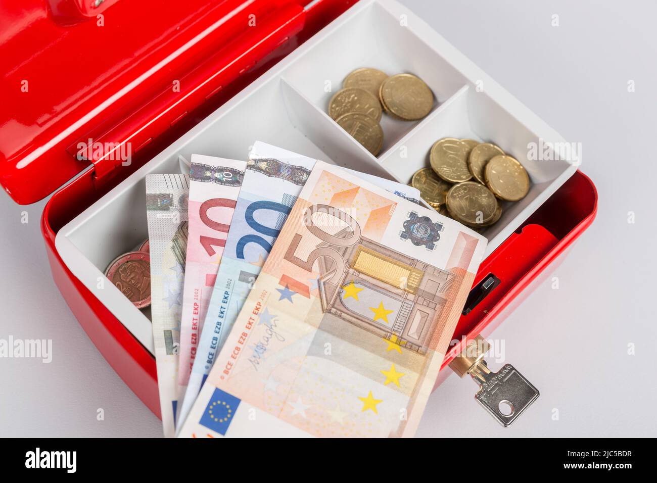 una cassa piena di soldi e un giornale di cassa Foto Stock