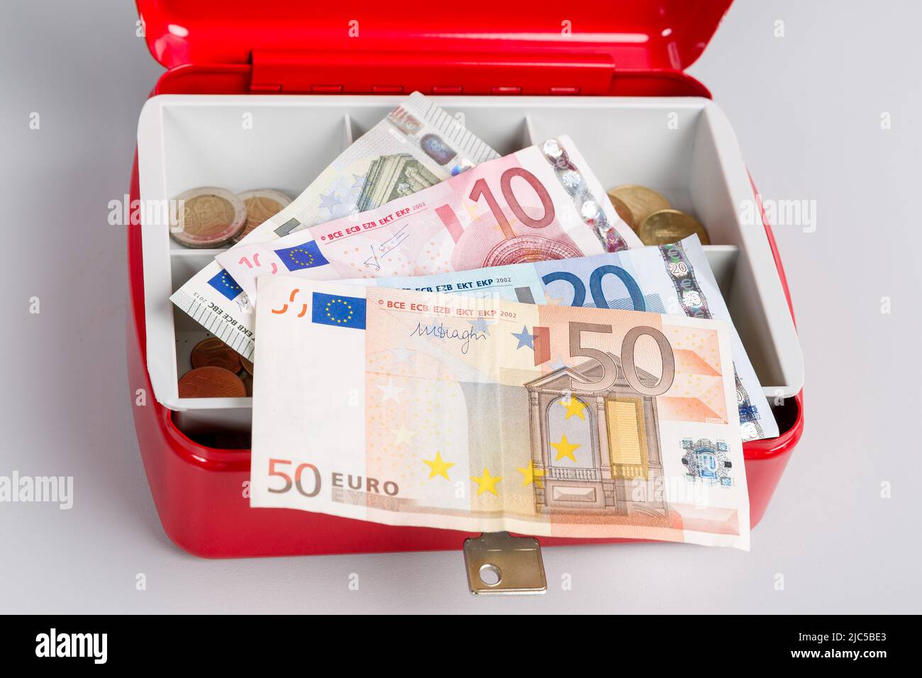 una cassa piena di soldi e un giornale di cassa Foto Stock