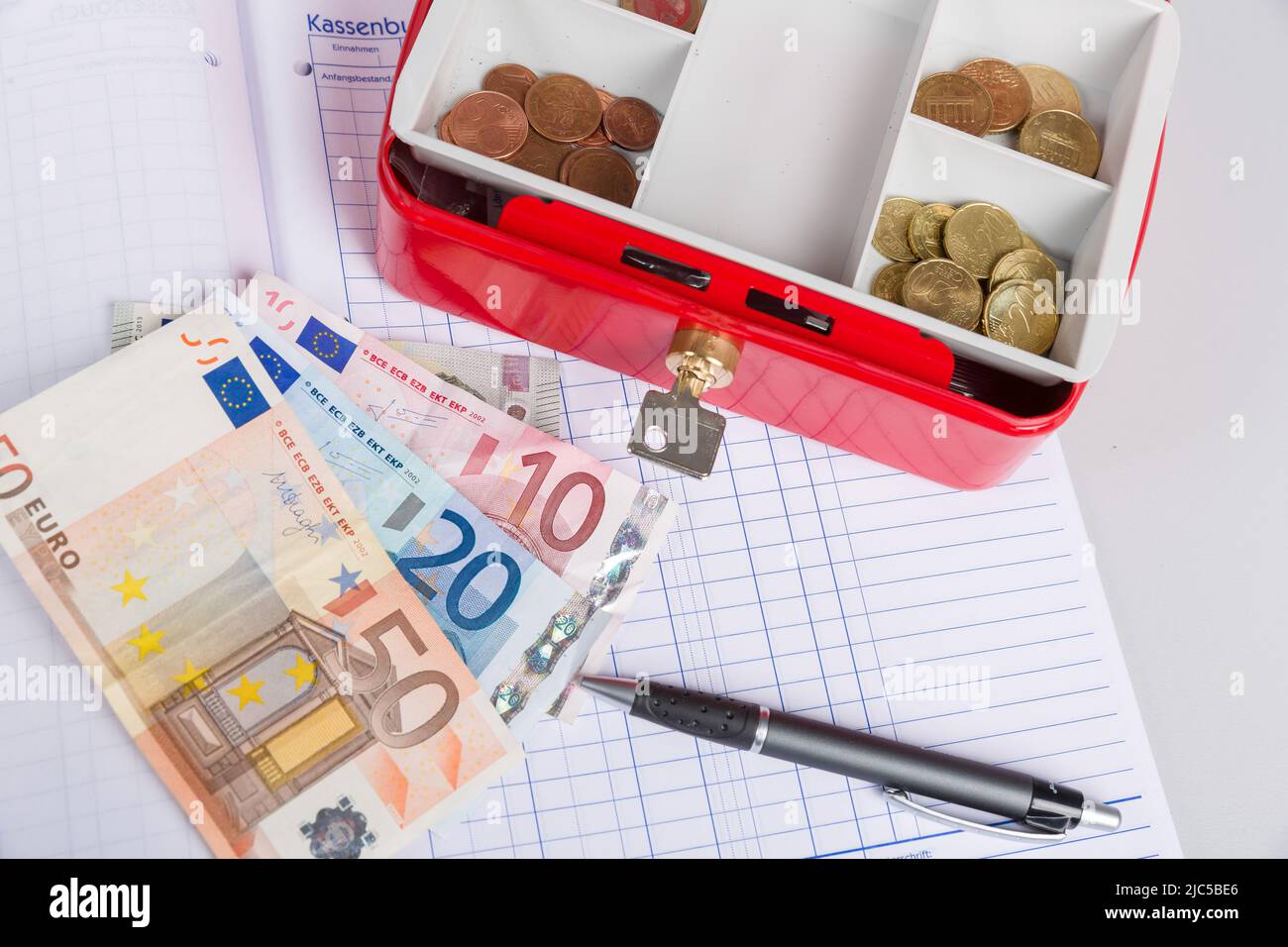 una cassa piena di soldi e un giornale di cassa Foto Stock