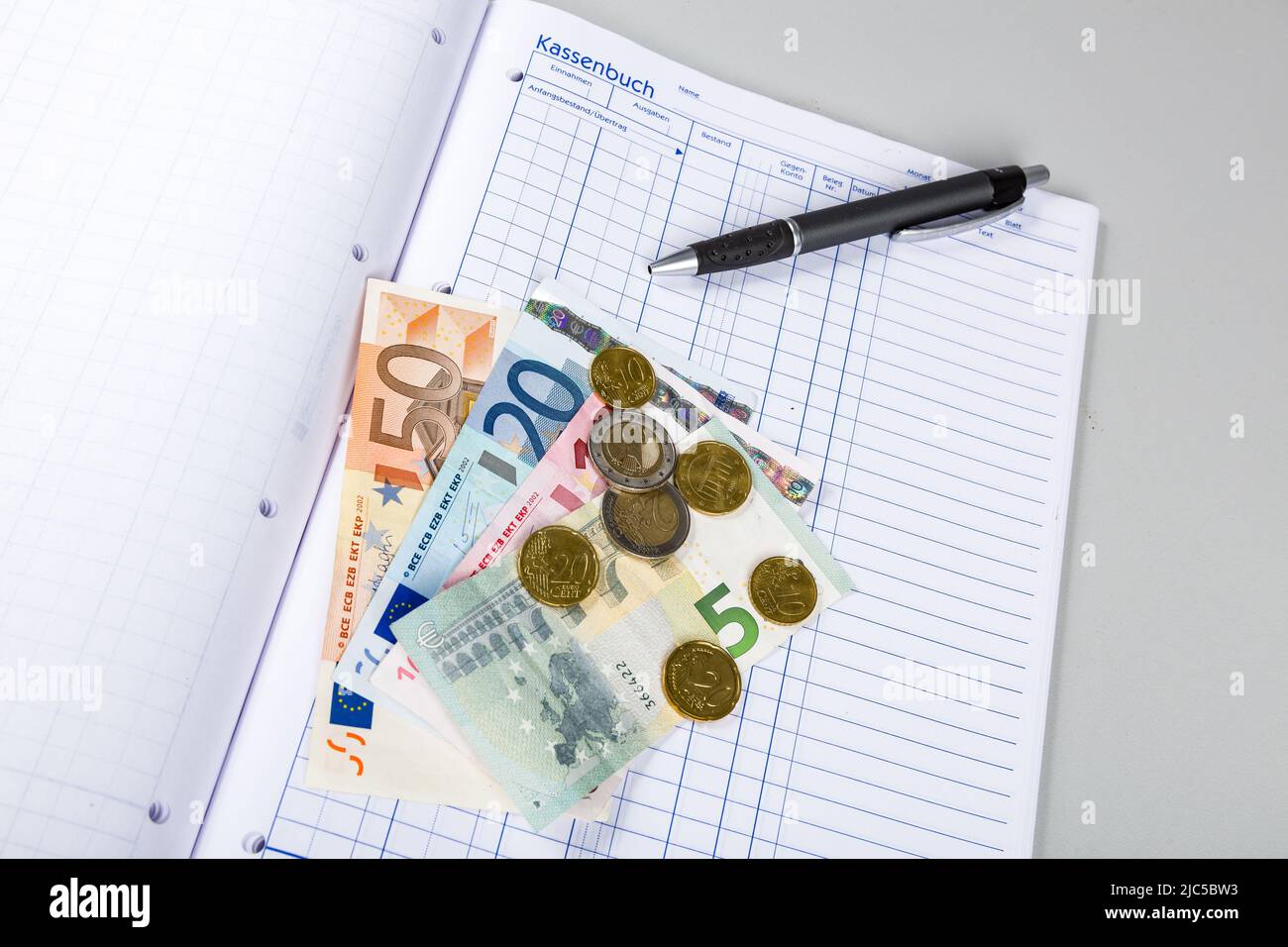 una cassa piena di soldi e un giornale di cassa Foto Stock