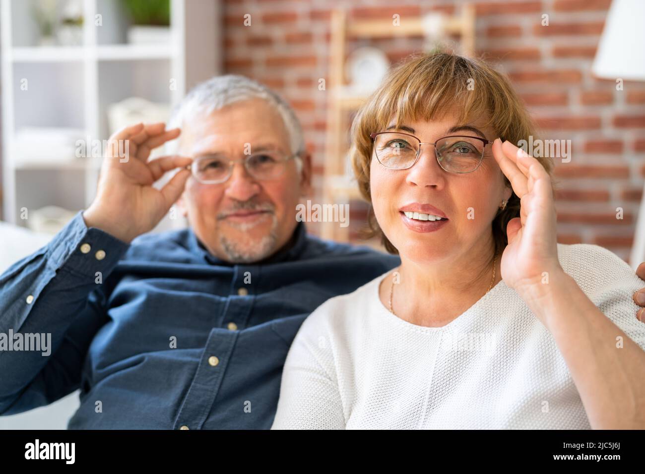 Happy Couple Family indossare occhiali da vista sul divano Foto Stock