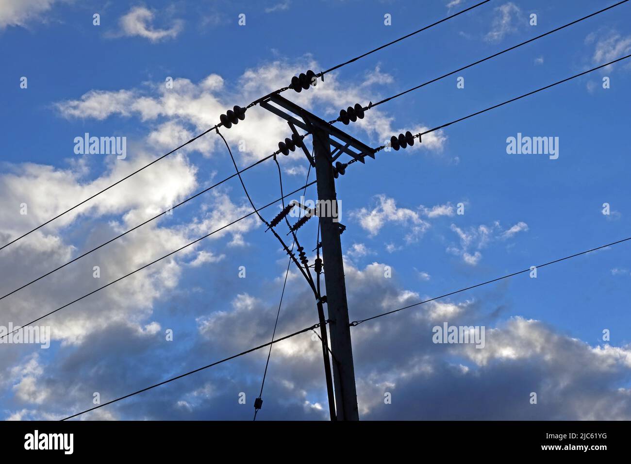 Distribuzione rurale di linee elettriche trifase, con isolatori contro un cielo nuvoloso blu, Cheshire, Inghilterra, UK, WA4 Foto Stock