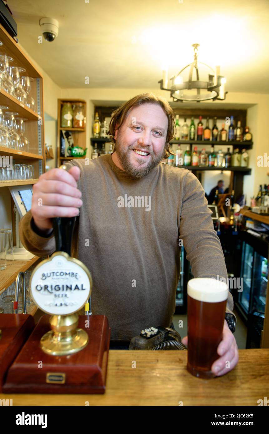 Uomo che serve birra al Packhorse Community Pub South Stoke, Somerset UK Foto Stock