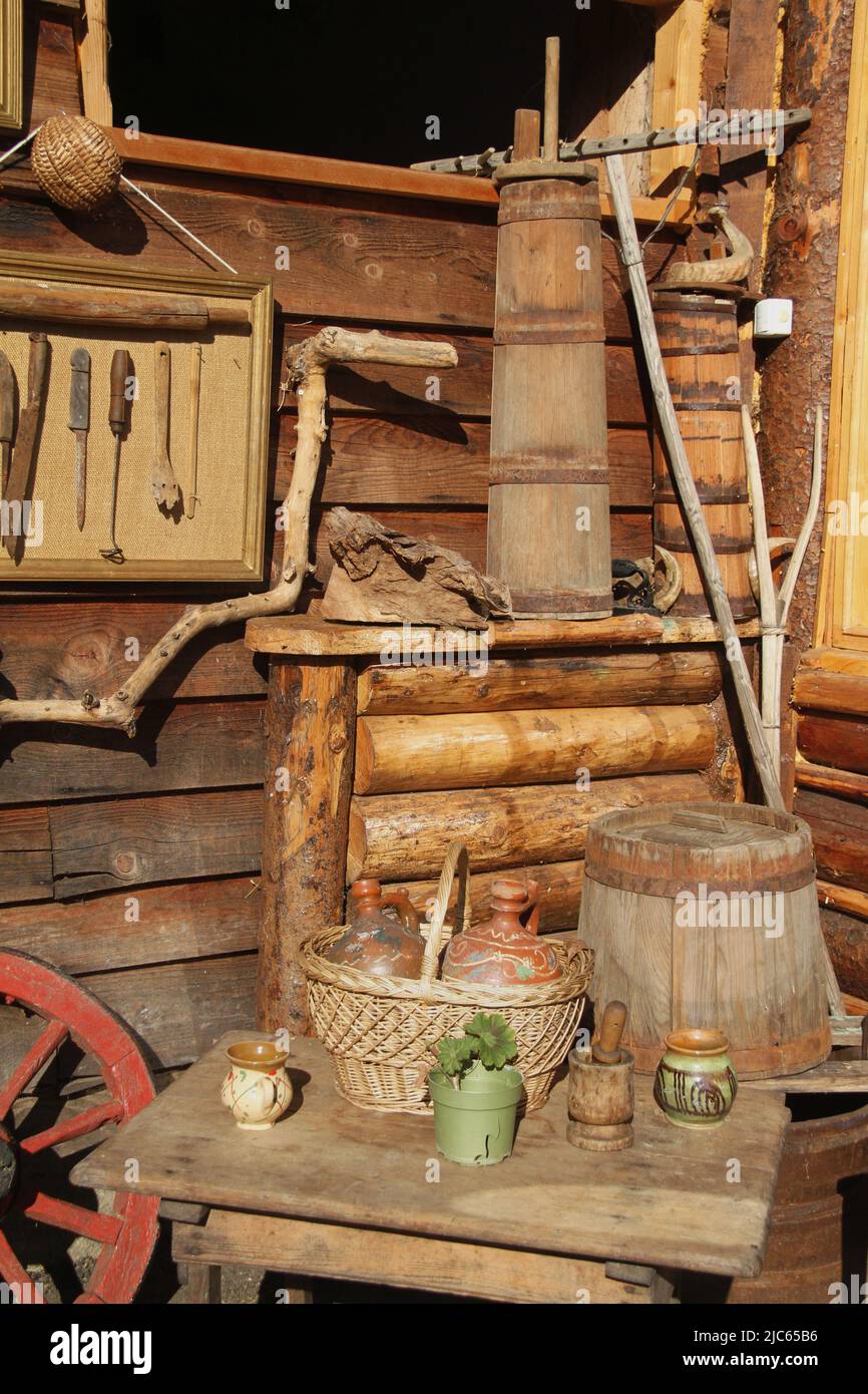 Sistemazione di vecchi oggetti popolari tradizionali all'esterno di un  fienile in Romania. Briciolle di burro di legno Foto stock - Alamy