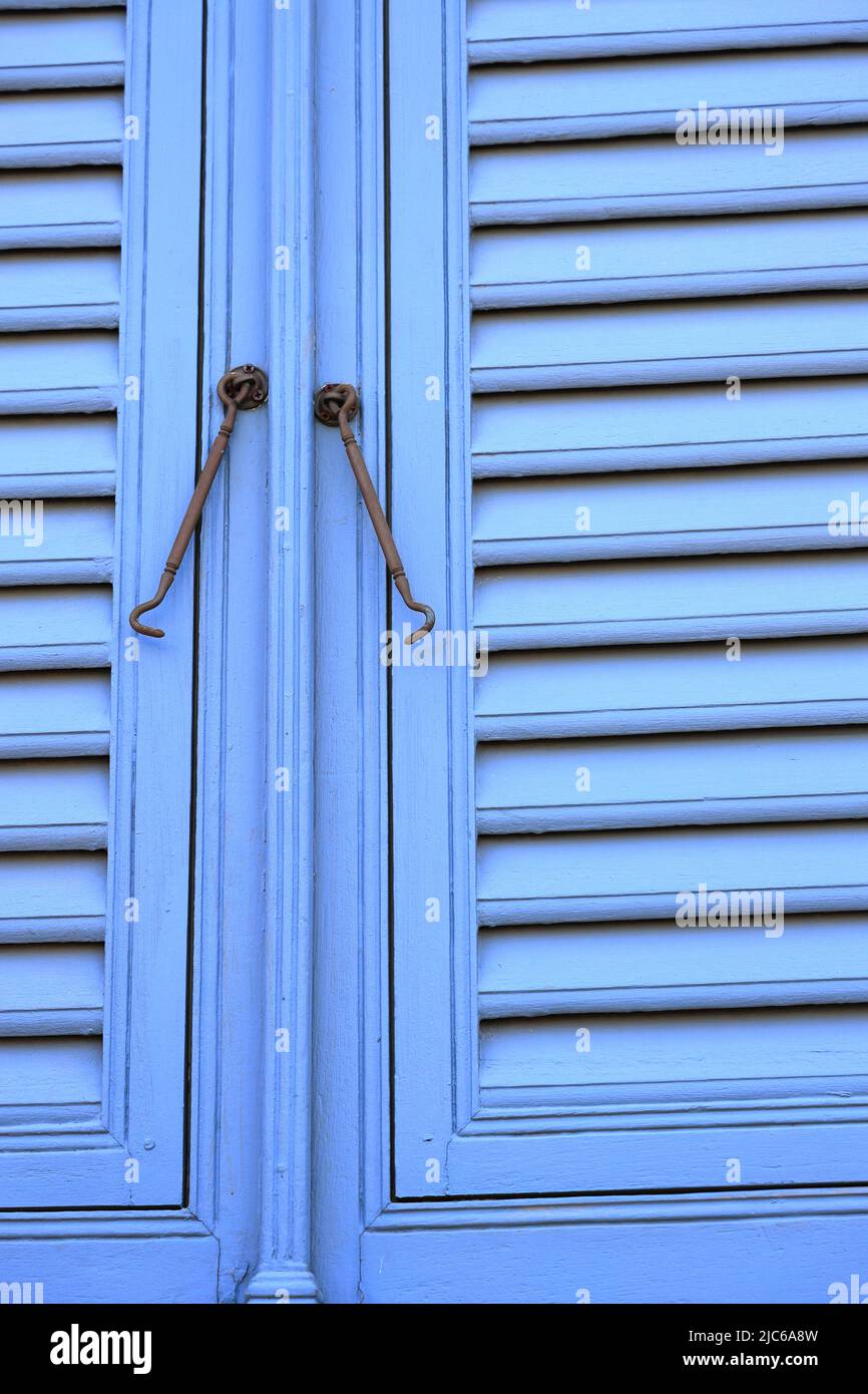 Chiusure per finestre vintage o gancio per serramenti in metallo o gancio per finestre montato su pareti in legno blu Foto Stock