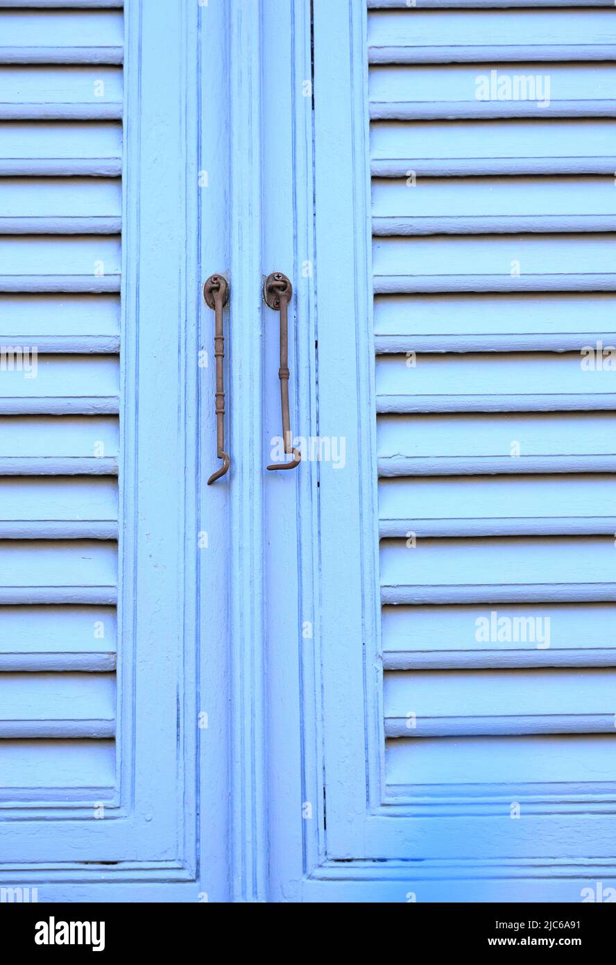 Chiusure per finestre vintage o gancio per serramenti in metallo o gancio per finestre montato su pareti in legno blu Foto Stock