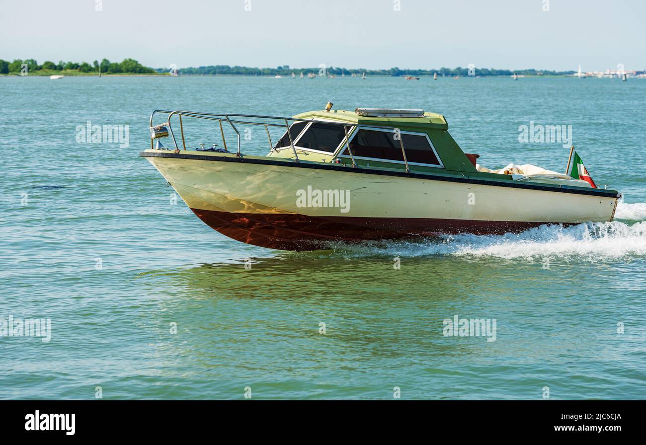 Piccolo motoscafo in movimento nella laguna veneta, il modo più veloce per viaggiare in questa città. Venezia, Veneto, Europa. Foto Stock