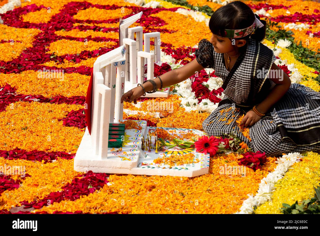 Una bambina rende omaggio ai martiri del movimento linguistico nel 1952, presso lo Shaheed Minar centrale, a Dhaka, in occasione della Giornata Internazionale della Lingua Madre; Foto Stock