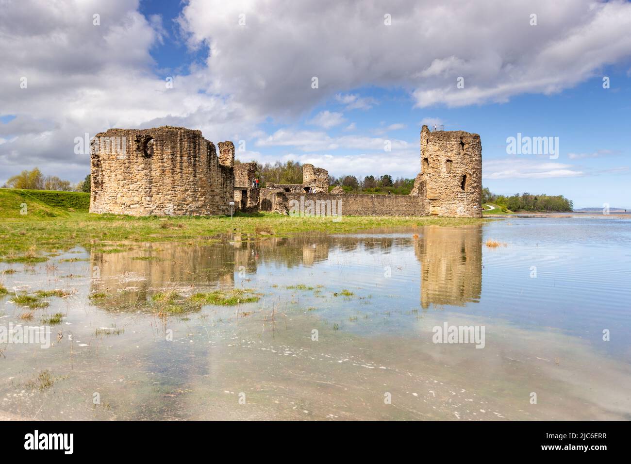 Flint castello in alta marea primavera, costa del Galles del Nord Foto Stock