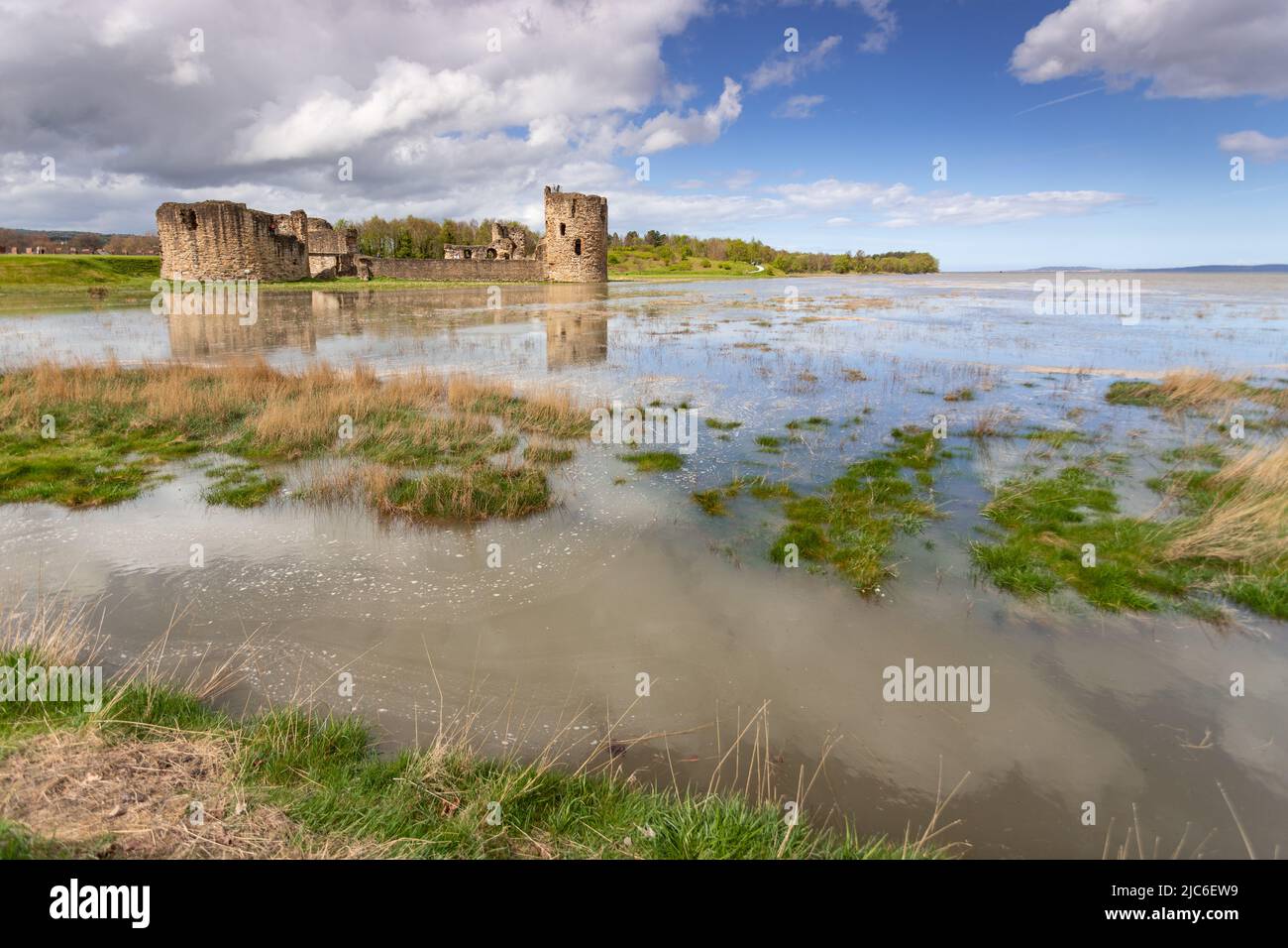 Flint castello in alta marea primavera, costa del Galles del Nord Foto Stock