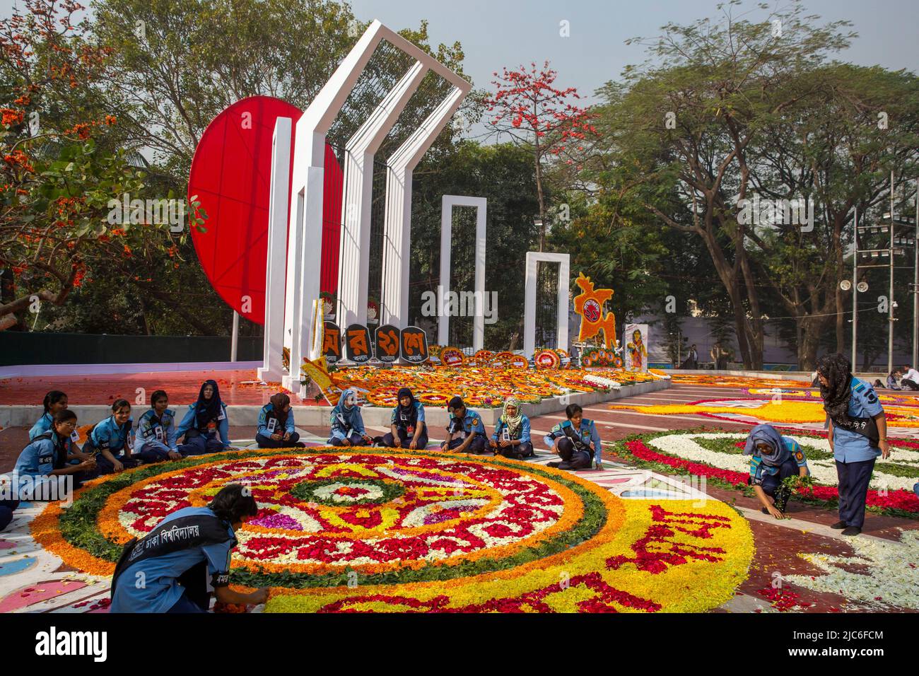 Volontari impegnati a decorare il Minar Shaheed centrale con fiori il 21st febbraio per onorare i martiri del movimento linguistico. Dhaka, Bangladesh. Foto Stock