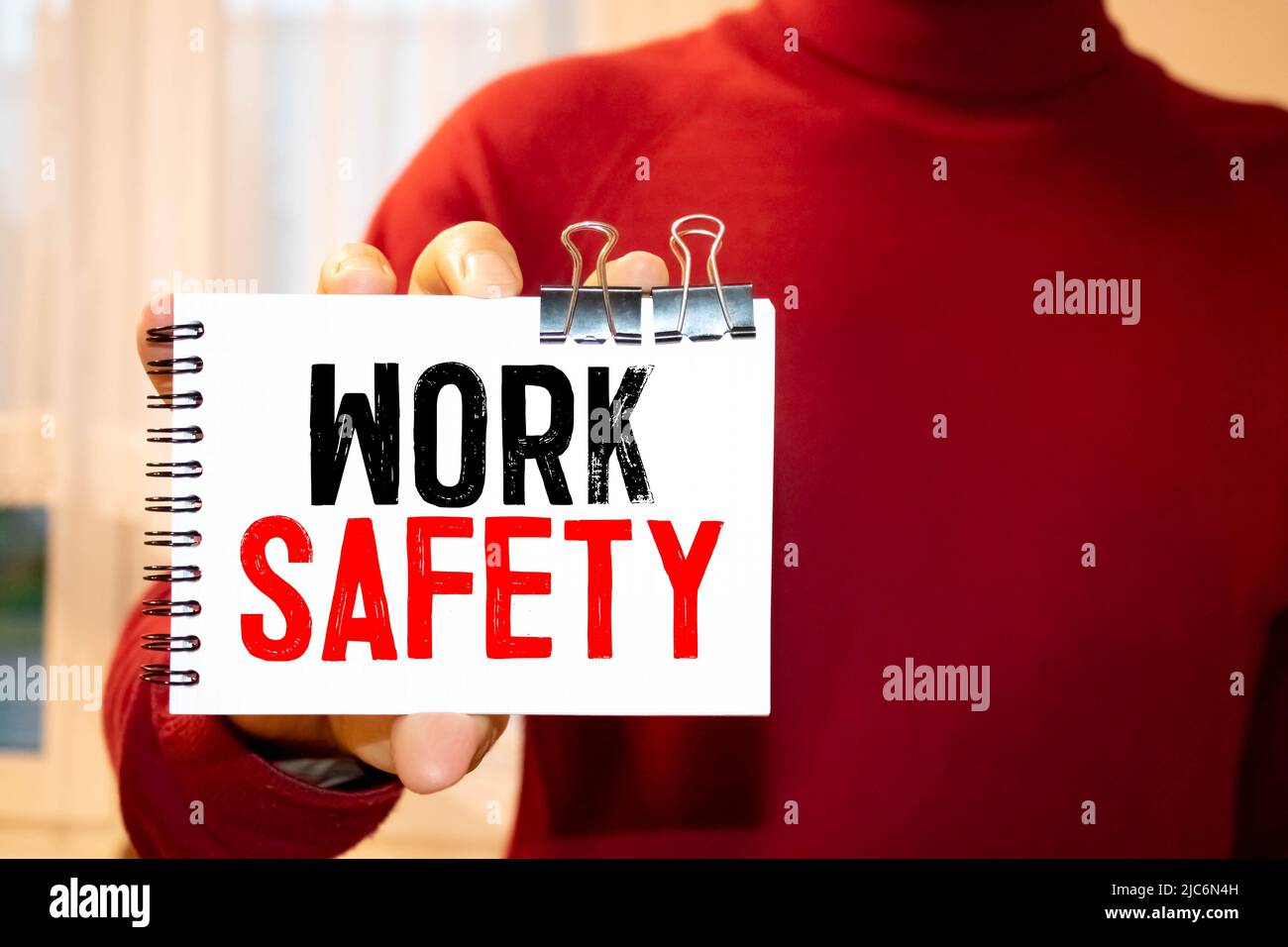 Sicurezza sul lavoro. Uomo che tiene una carta con un testo di messaggio scritto su di essa. Foto Stock