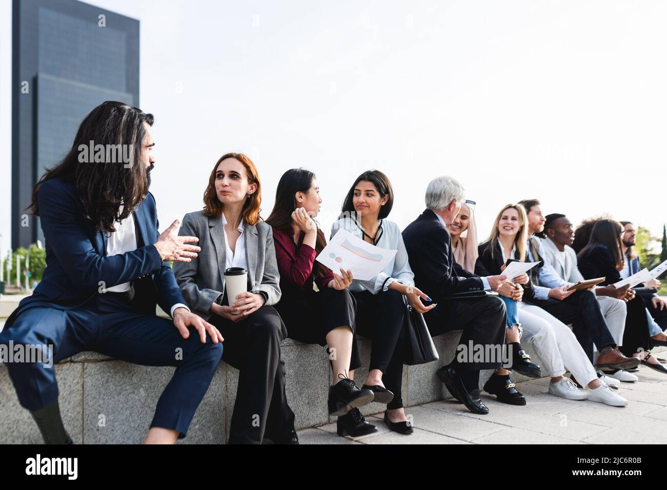 Gente di affari multirazziale che ha un briefing fuori dell'ufficio Foto Stock