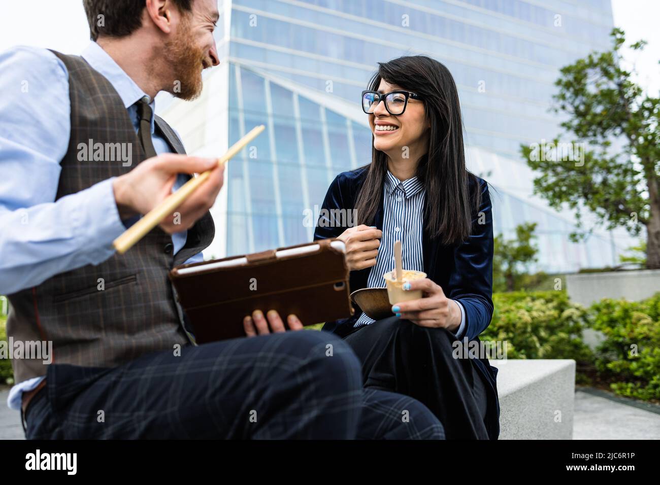 Uomini d'affari che mangiano un pasto fuori dall'ufficio Foto Stock