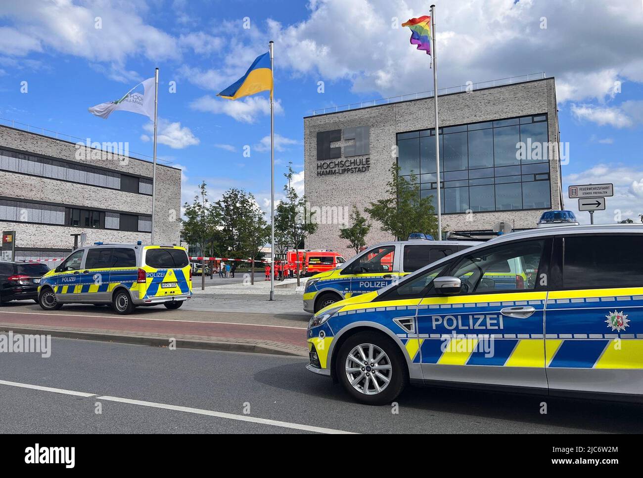 Hamm, Germania. 10th giugno 2022. I veicoli di emergenza della polizia sono parcheggiati di fronte all'edificio dell'Università di Scienze applicate di Hamm-Lippstadt. Alla Hamm-Lippstadt University of Applied Sciences, un uomo di 34 anni ha attaccato diverse persone con un coltello e ferito quattro persone, alcune delle quali seriamente. Fu sovralimentato dagli studenti e tenuto fino a quando gli ufficiali di polizia lo arrestarono. Credit: Festim Beqiri/TV7NEWS/dpa/Alamy Live News Foto Stock