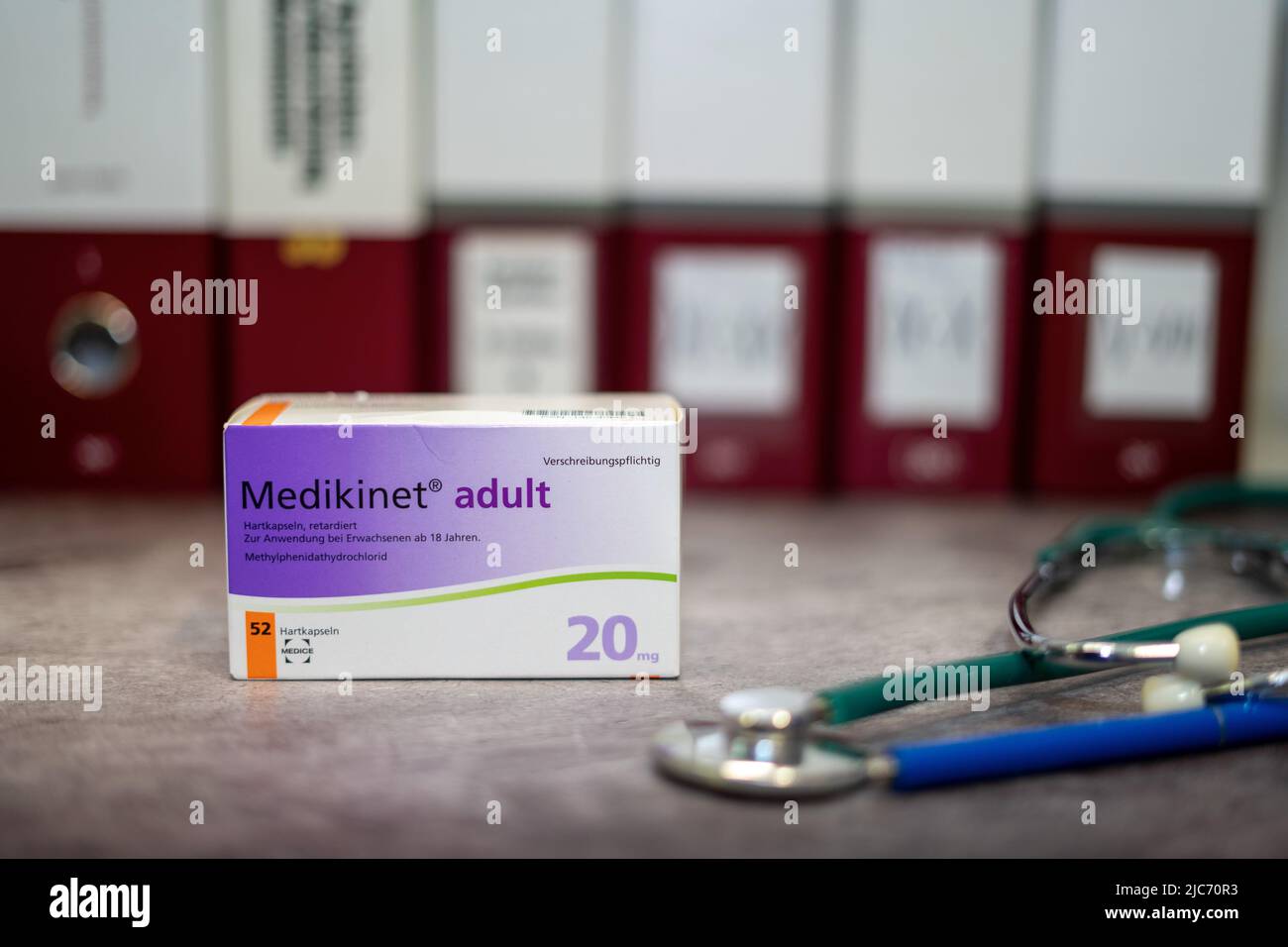 Una scatola di farmaci di Medikinet contenente metilfenidato per il trattamento del disturbo da deficit di attenzione e iperattività (ADHD), su un tavolo e sul dorso Foto Stock