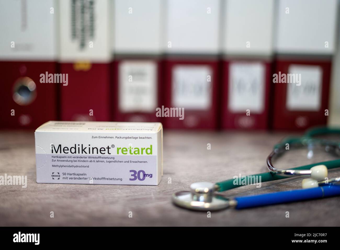Una scatola di farmaci di Medikinet contenente metilfenidato per il trattamento del disturbo da deficit di attenzione e iperattività (ADHD), su un tavolo e sul dorso Foto Stock