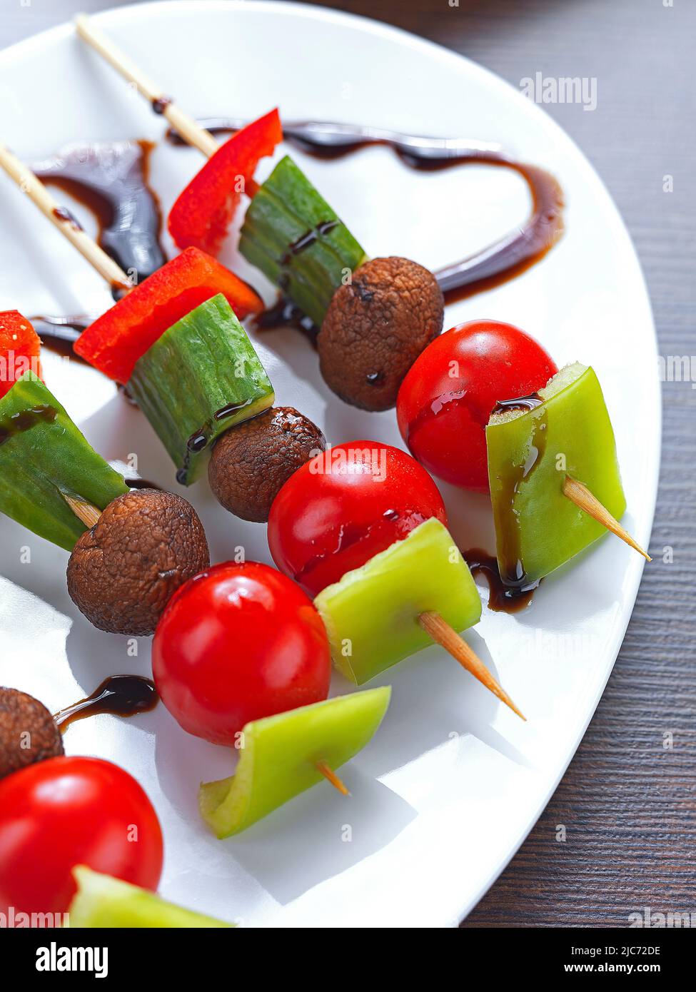 un souvlaki di verdure miste a base di pepe rosso e verde, pomodoro ciliegia, funghi e cetriolo con salsa all'aceto balsamico Foto Stock