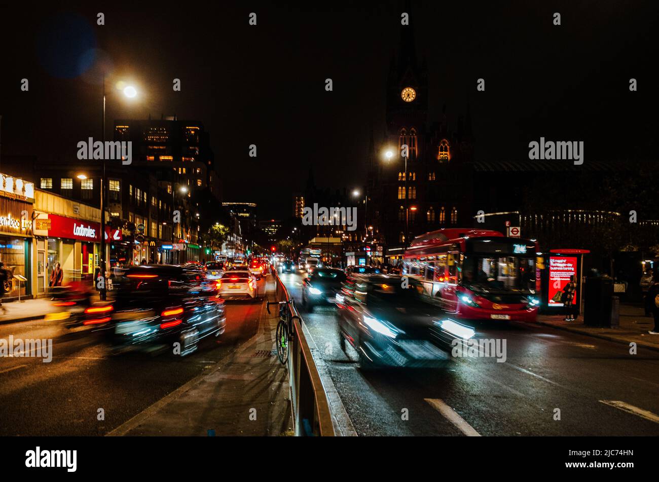 Traffico notturno lungo Euston Road al di fuori della stazione dei treni di Kings Cross, Londra - esposizione notturna. Foto Stock