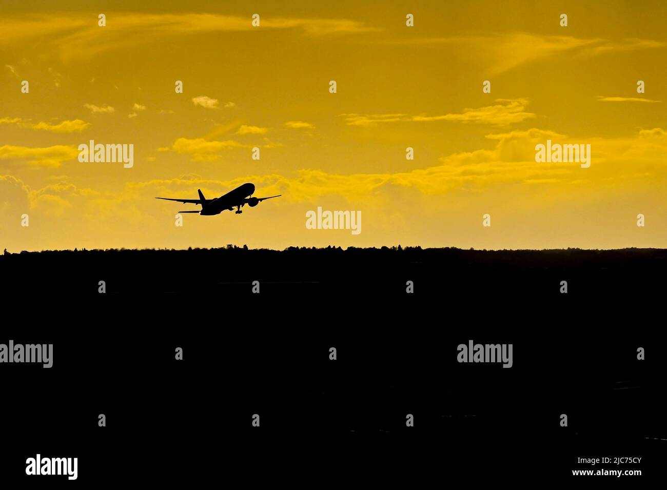 Silhouette di un aereo passeggeri che parte da un aeroporto al tramonto. Nessuna gente. Spazio di copia. Foto Stock