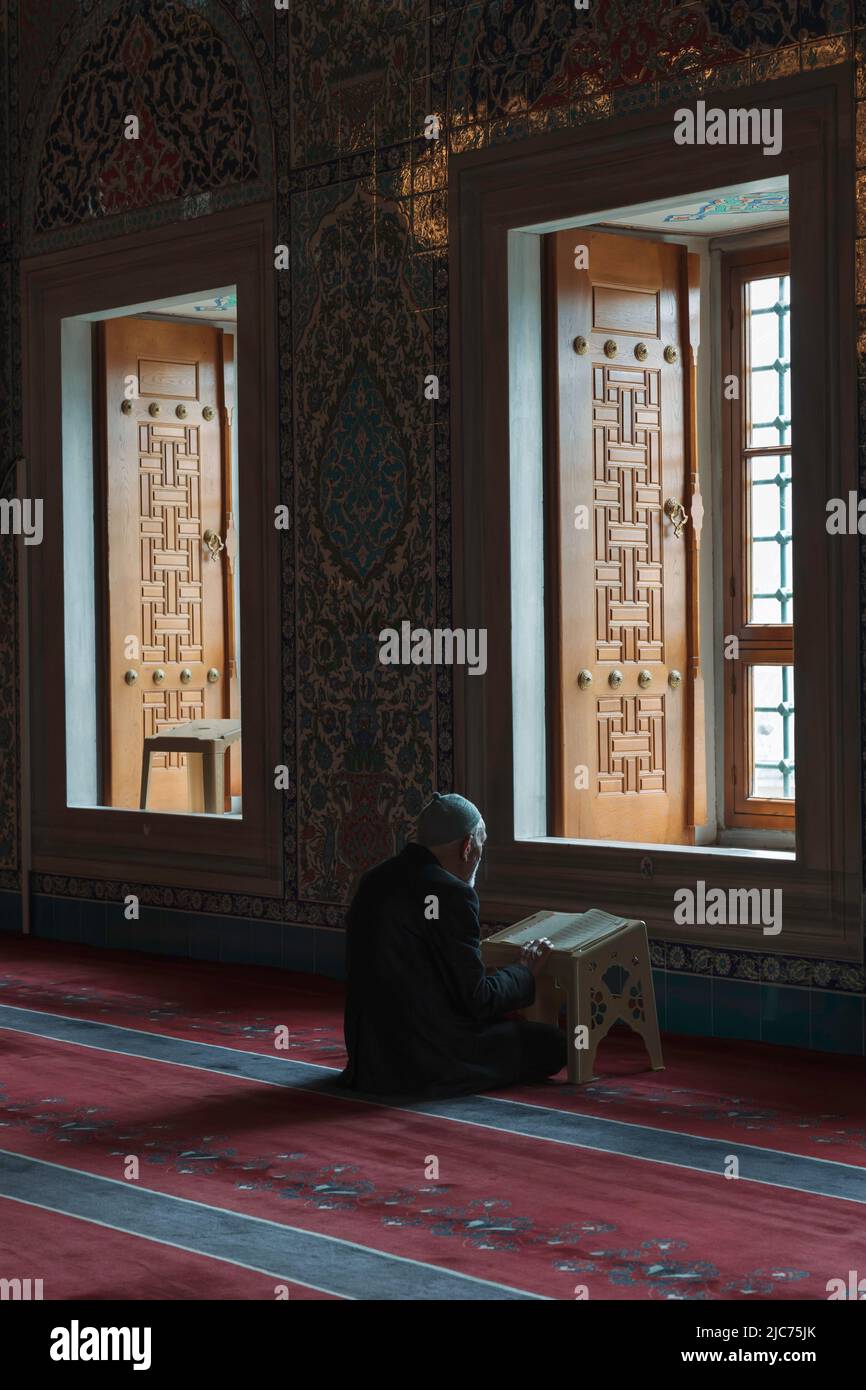 Foto islamica. Un vecchio musulmano che legge il Corano nella moschea. Ramadan o kandil o laylat al-qadr o kadir gecesi o foto verticale di sfondo islamico Foto Stock