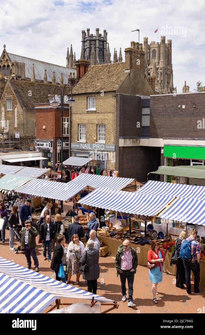 Ely Cambridgeshire Regno Unito; gente che acquista nel mercato di Ely con la cattedrale di Ely sullo sfondo, centro città di Ely, in una giornata di sole in estate, Regno Unito Foto Stock