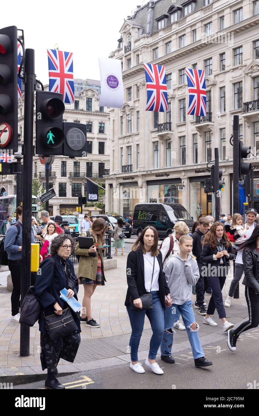 Stile di vita di Londra; pedoni che attraversano la strada in un passaggio pedonale nel centro di Londra; Oxford Circus, centro di Londra, Londra Regno Unito Foto Stock