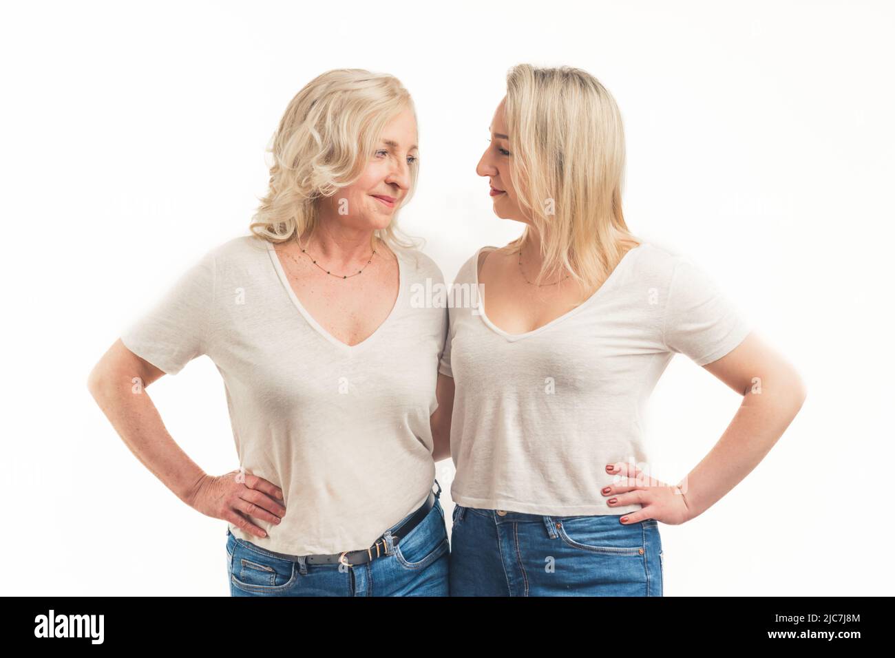 Due bionda donne caucasiche che si parlano a vicenda amorevolmente medio scatto studio shot bianco sfondo femminile concetto. Foto di alta qualità Foto Stock