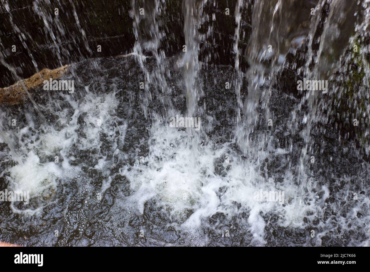 Dettaglio dell'acqua che cade nella fontana Foto Stock