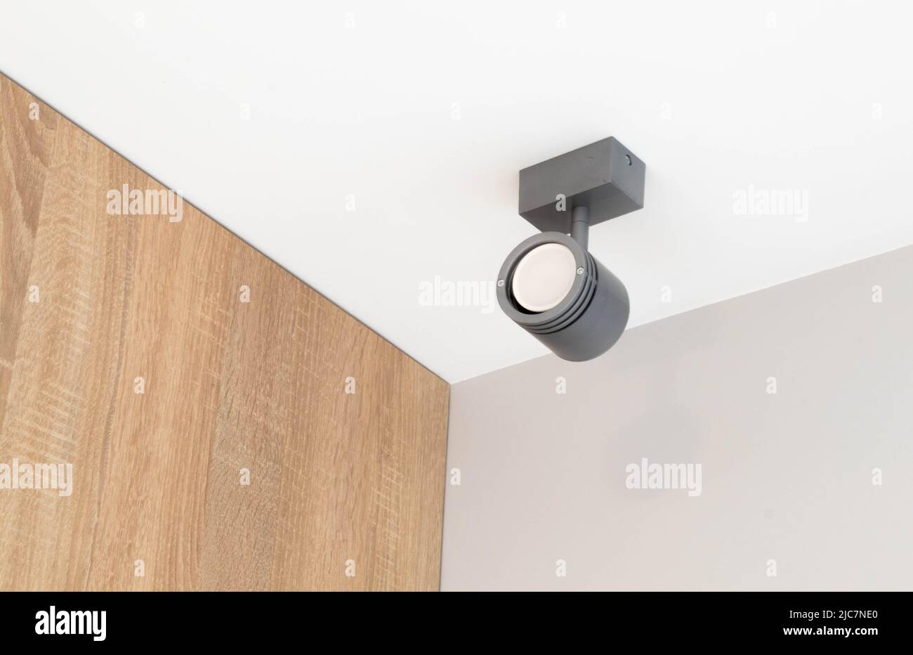 Faretto rotondo isolato montato su soffitto bianco con riflettore a luce argento visibile. Foto Stock