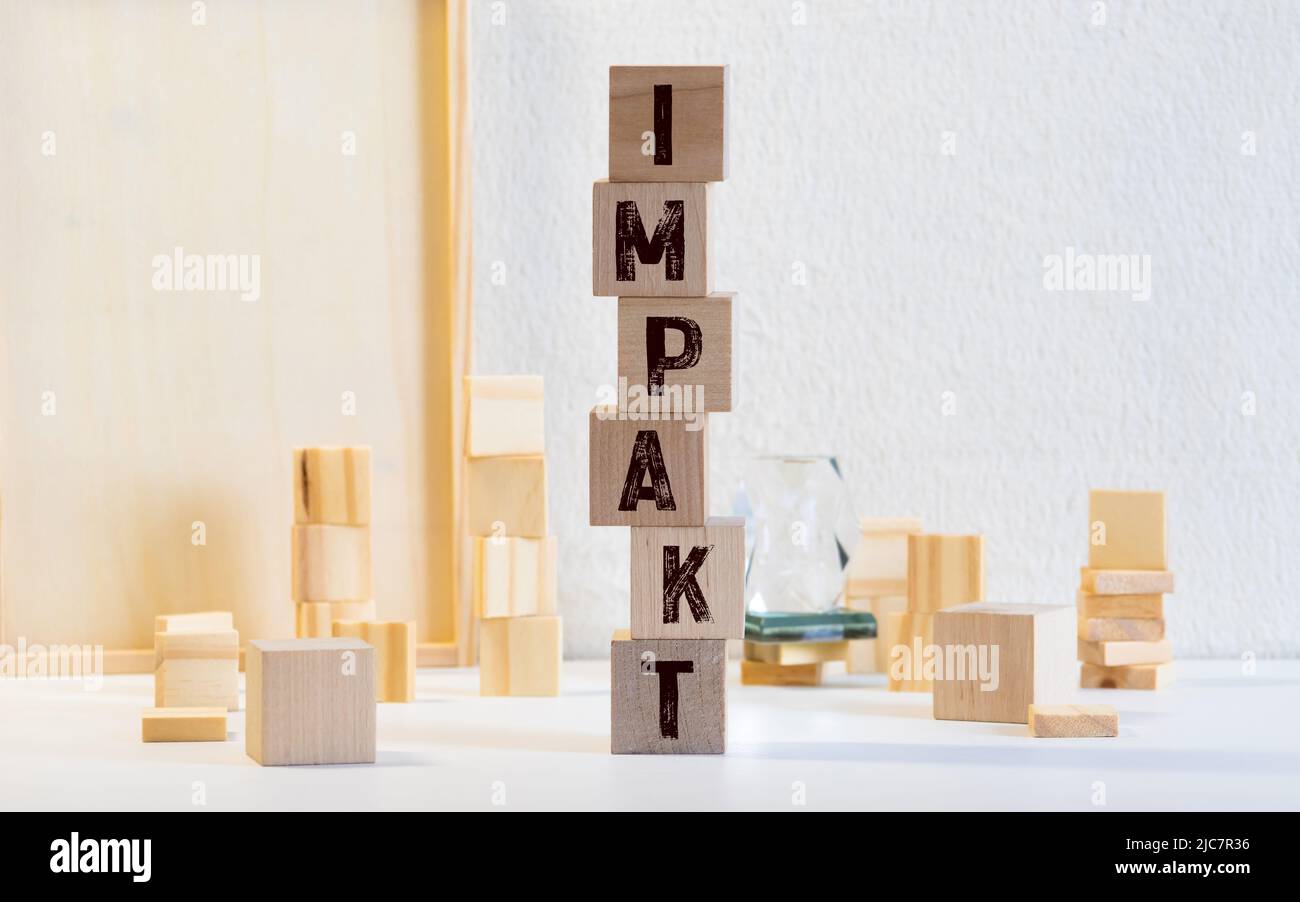 parola di impatto scritta sul blocco di legno. Foto Stock