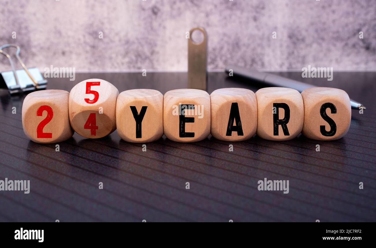 La mano gira i dadi e cambia l'espressione da 24 anni a 25 anni. Foto Stock