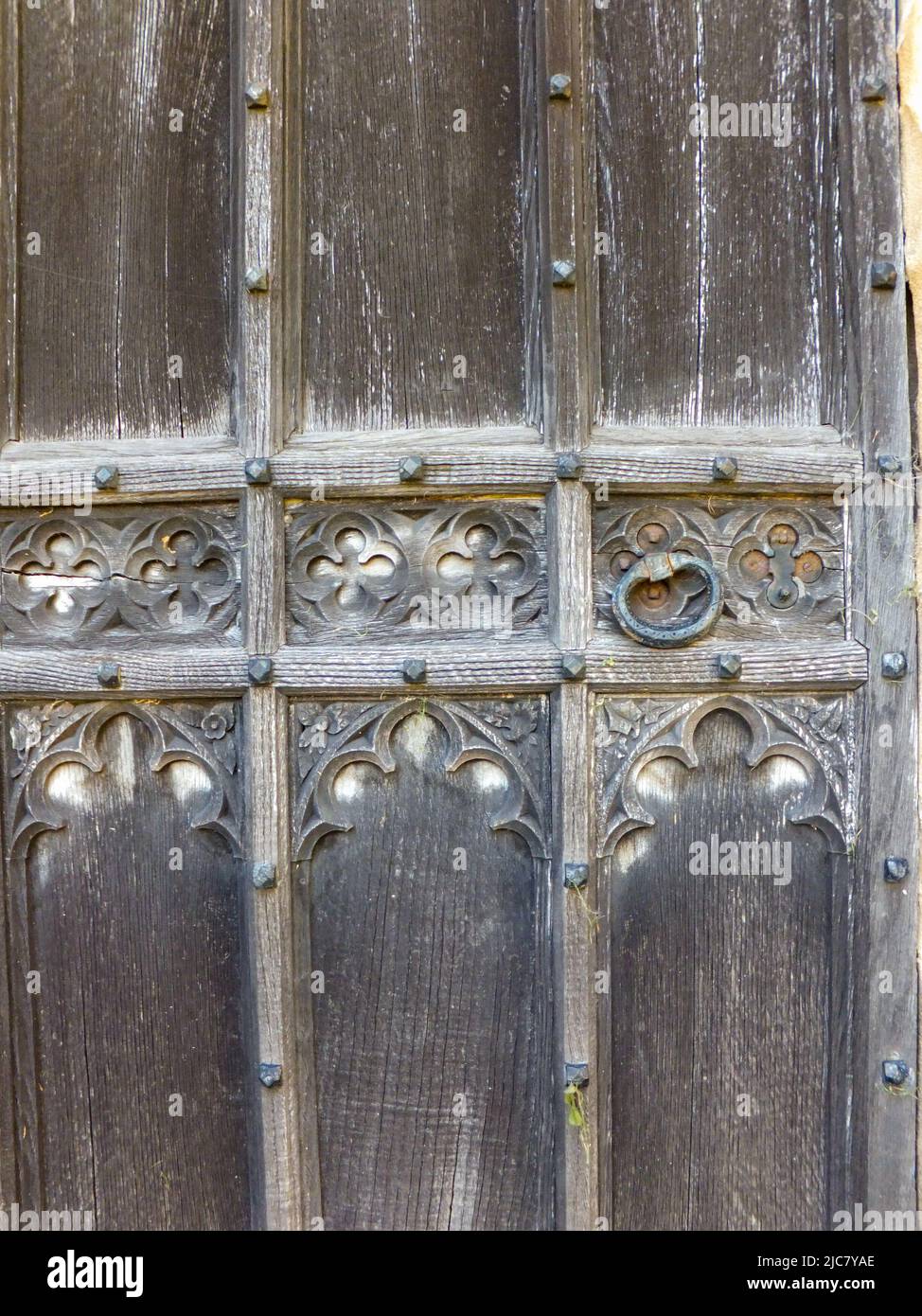 Un'antica porta di legno con disegni di quatrefoil. Foto Stock