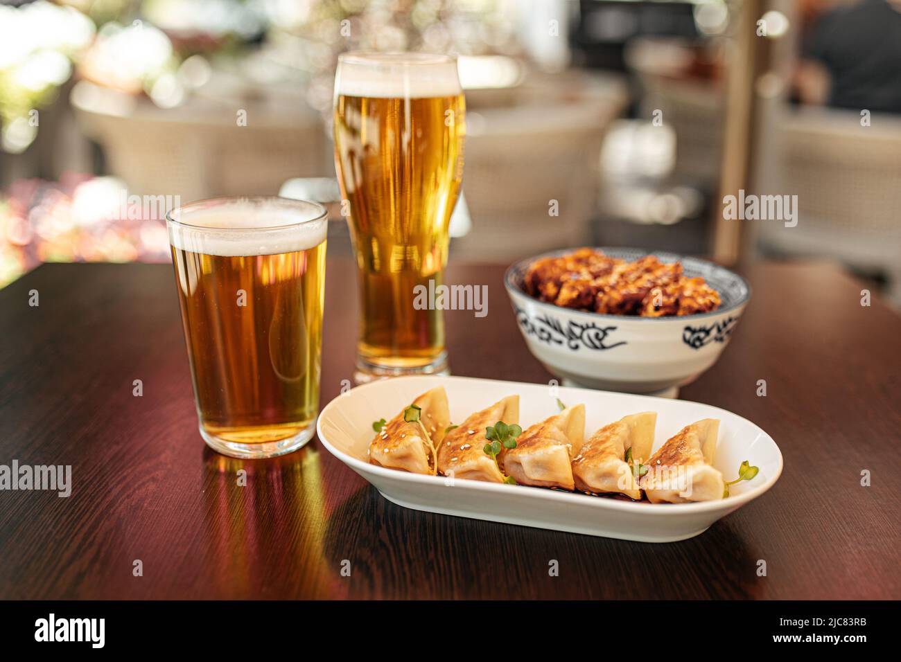 Porzione di gnocchi giapponesi di gyoza con birra Foto Stock